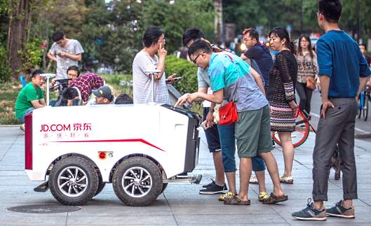 中国人民大学の学生が物珍しそうにJD.com（京東商城）の無人カートを見つめる
