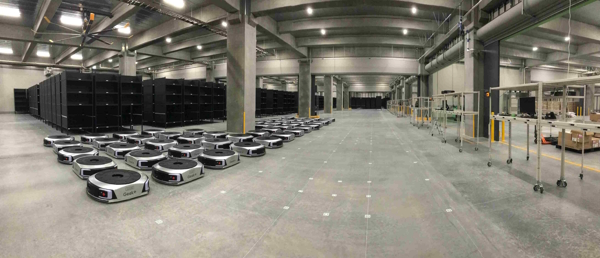 倉庫内で稼働する自動棚搬送ロボット（画像左側）