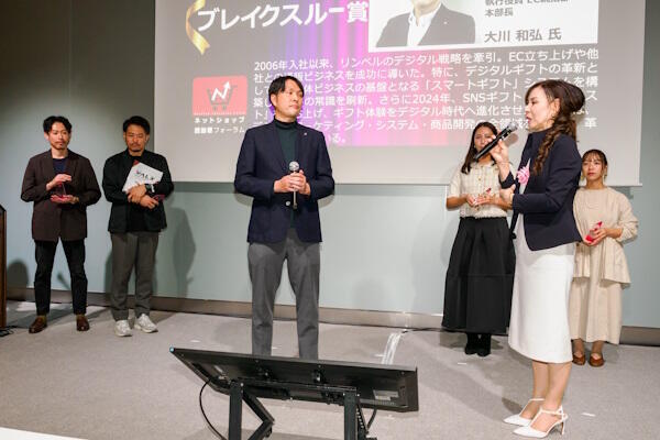 リンベルの大川氏（写真中央）と田丸選考委員（手前右、SRSホールディングス 執行役員SRSグループDX推進本部長）