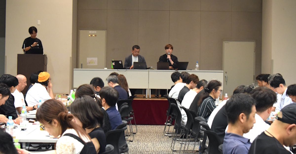 講演する澤井珈琲の澤井理憲取締役社長(写真中央左)と九南サービスの田中耕太郎社長(写真中央右)