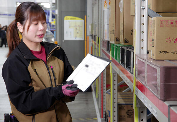 情報を印刷した紙と商品を見比べてチェックしている