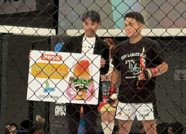 リング上で賞の贈呈を行う宮﨑明代表取締役(写真左)