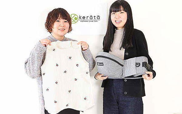 濱氏（左）が手に持つ製品：韓国寝具「イブル」をモチーフにデザインした赤ちゃん用寝具「ibul（イブル）スリーパー」（6重ガーゼ／チェリー刺繍）。高田氏が手に持つ製品：3月に新発売したヒップシートの新製品「ダイヤルフィット®️」